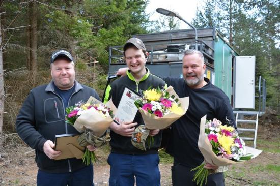 Sveriges bästa maskinlag, Granvikslaget, med blommor och diplom. Från vänster: Skördarförarna Krister Lundin och Henrik Magnusson samt skotarförare Andreas Johansson.