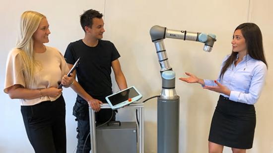 Projektledare Susanna &Ouml;sterlund, automationsingenjör Tommy Apelgren och projektledare Shammeran Benjamin vid en av de robotar som ska levereras till kund för att ingå i arbetslaget.