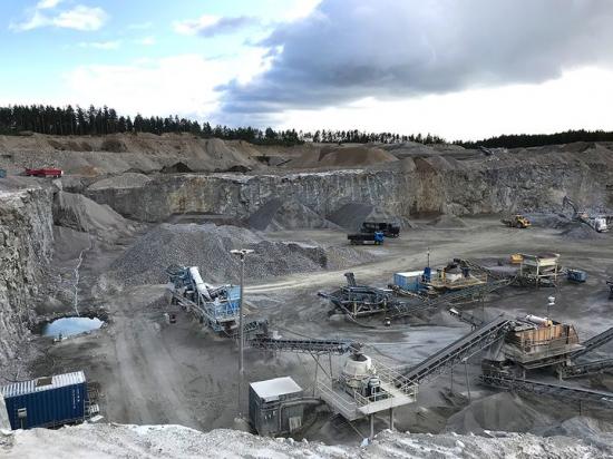 Finkornig granit som bryts i Malmby bergtäkt. Inom Malmbytäkten har man visat att denna bergart kan förädlas till flera olika ersättningsmaterial för naturgrus. Det mesta av bergmaterialet från denna täkt levereras till betongtillverkning.