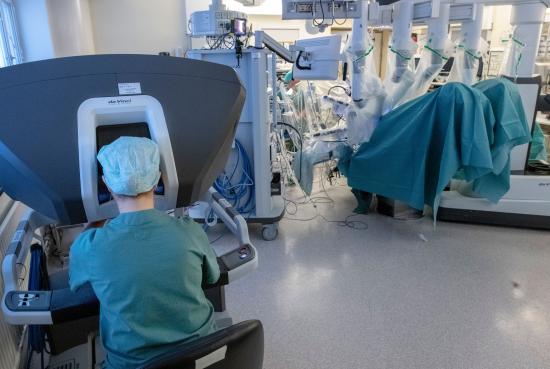 Operationssal med styrstation till vänster och patient till höger.