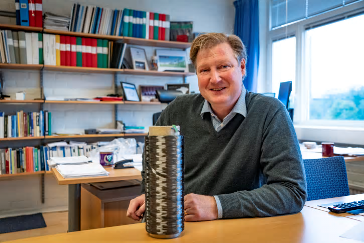 Leif Asp med en spole med kolfibergarn. Elektroderna i ett strukturellt litiumjonbatteri består av kolfibergarn som ligger i ett rutnät i en polymer (se illustration). Varje garntråd består av 24 000 enskilda kolfibrer.