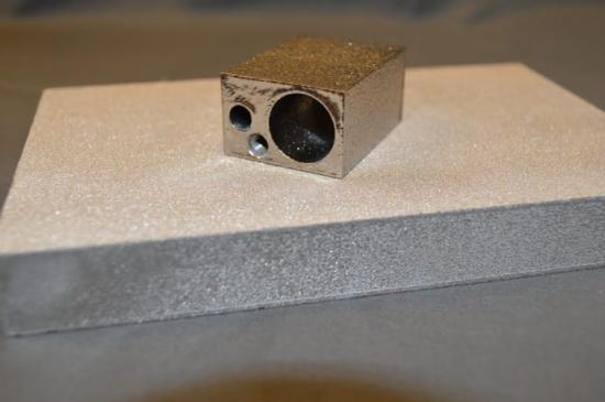 Bilden visar skillnaden mellan ett 3D-printat föremål (det övre) som har genomgått efterbearbetning och ett föremål (det undre) som inte efterbearbetats.