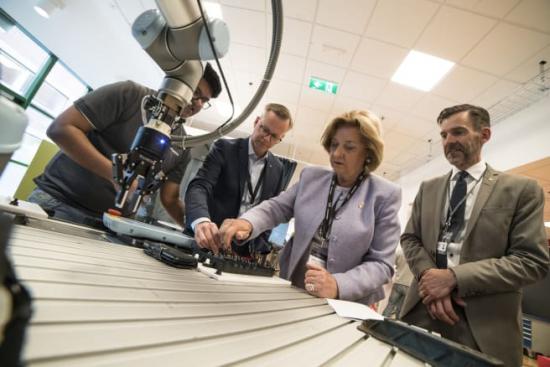 Doktoranden Omkar Salunkhe visar för Mikael Damberg, Madeleine Olsson Eriksson och Fredrik Hörstedt hur en montör och en robot kan samarbeta vid montering.