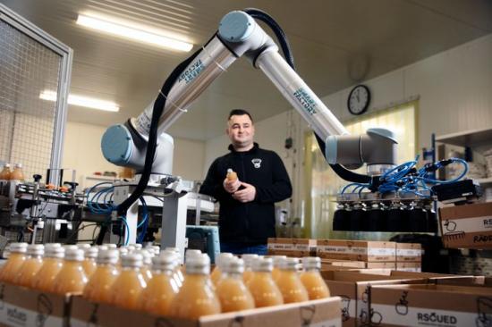 Tidigare packades de närmare 80-gradiga flaskorna för hand. Nu tar en robot från Universal Robots hand om det momentet, visar fabrikschef Marko Tukaric.